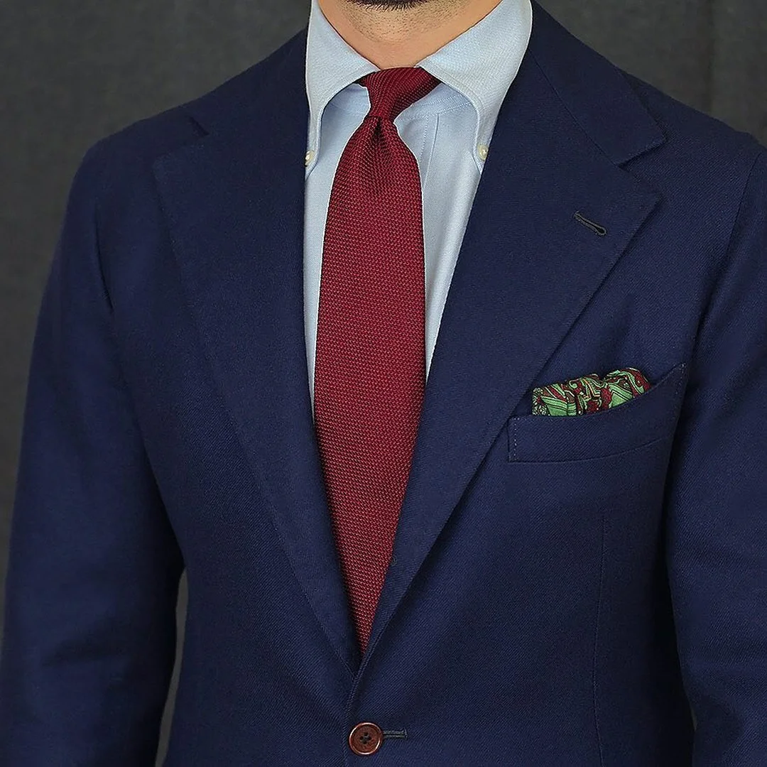 Raudonas kaklaraištis ir mėlynas kostiumas
