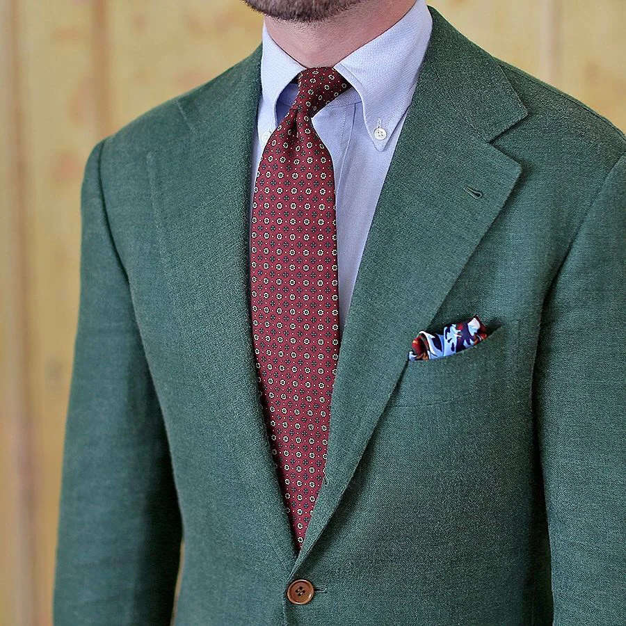 Raudonas kaklaraištis ir žalias kostiumas